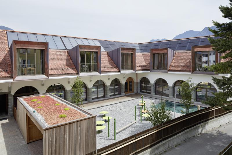Innenhofansicht des sanierten Gebäudekom-plexes mit DWHG und Doppelkindergarten mit Baujahr 1914 und einem Energiebedarf von 29’400 kWh/a.