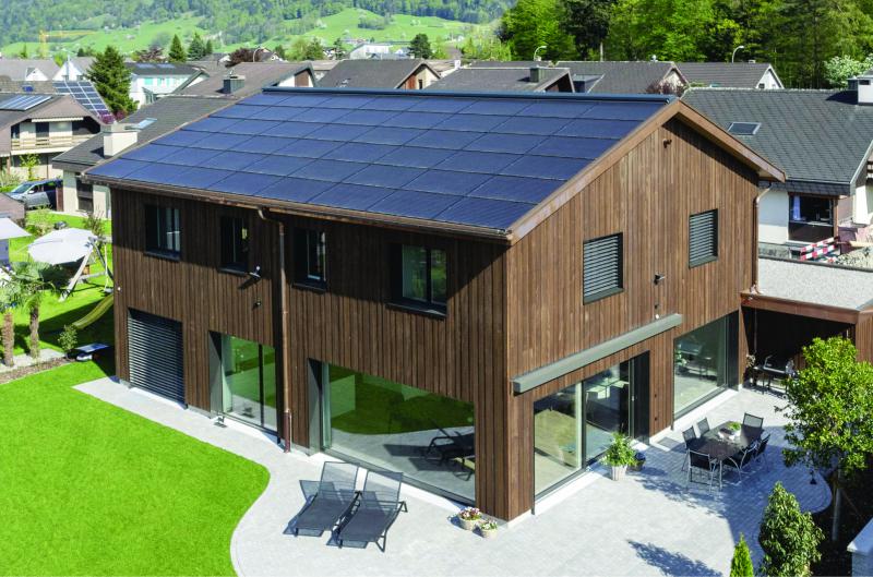 Die 29 kW starke, ganzflächig dachintegrierte PV-Anlage harmoniert mit der Holzfassade aus Weisstanne.