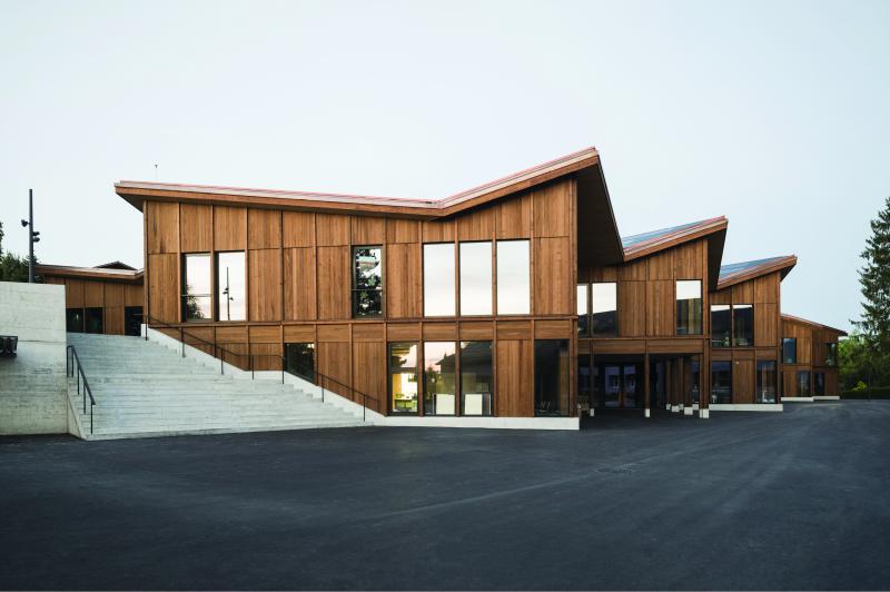 Die PlusEnergie-Schule besticht mit ihrer dunkelbraunen Fassade aus Weisstannenholz